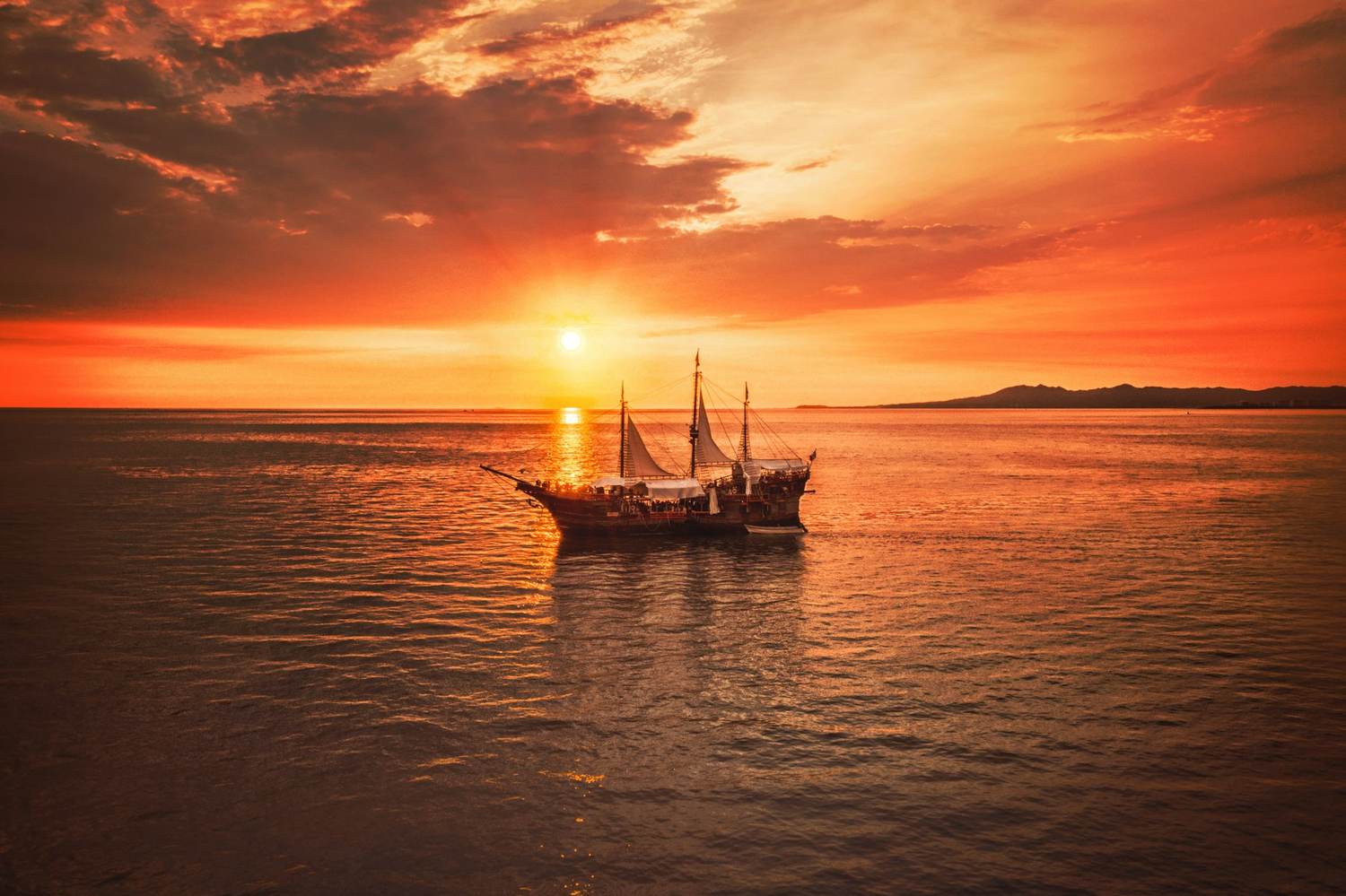 A traditional sailing boat silhouetted against a fiery Zanzibar sunset